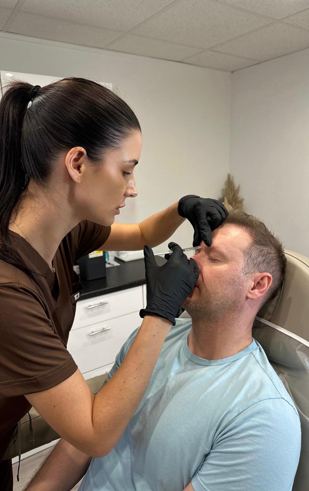 Jennifer carrying out a facial filler treatment in clinic